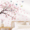 Decorative peach tree branches with pink blossoms and colorful birds on a white wall