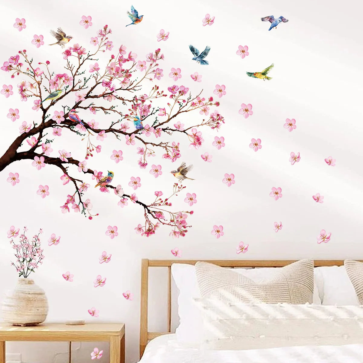 Decorative peach tree branches with pink blossoms and colorful birds on a white wall
