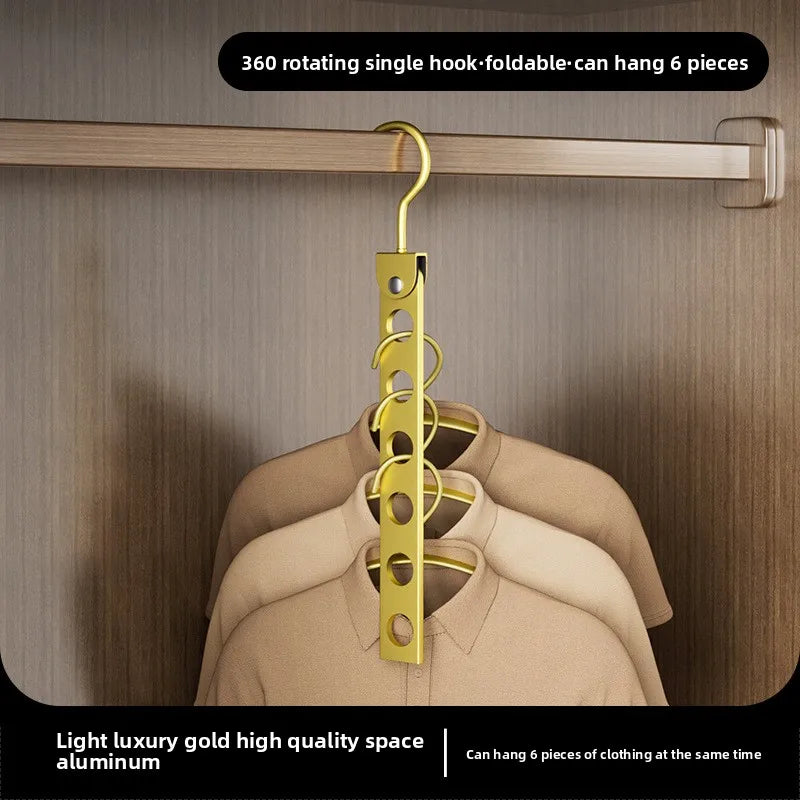 A gold-colored rotating single hook foldable hanger hanging six pieces of clothing on a wooden rack.