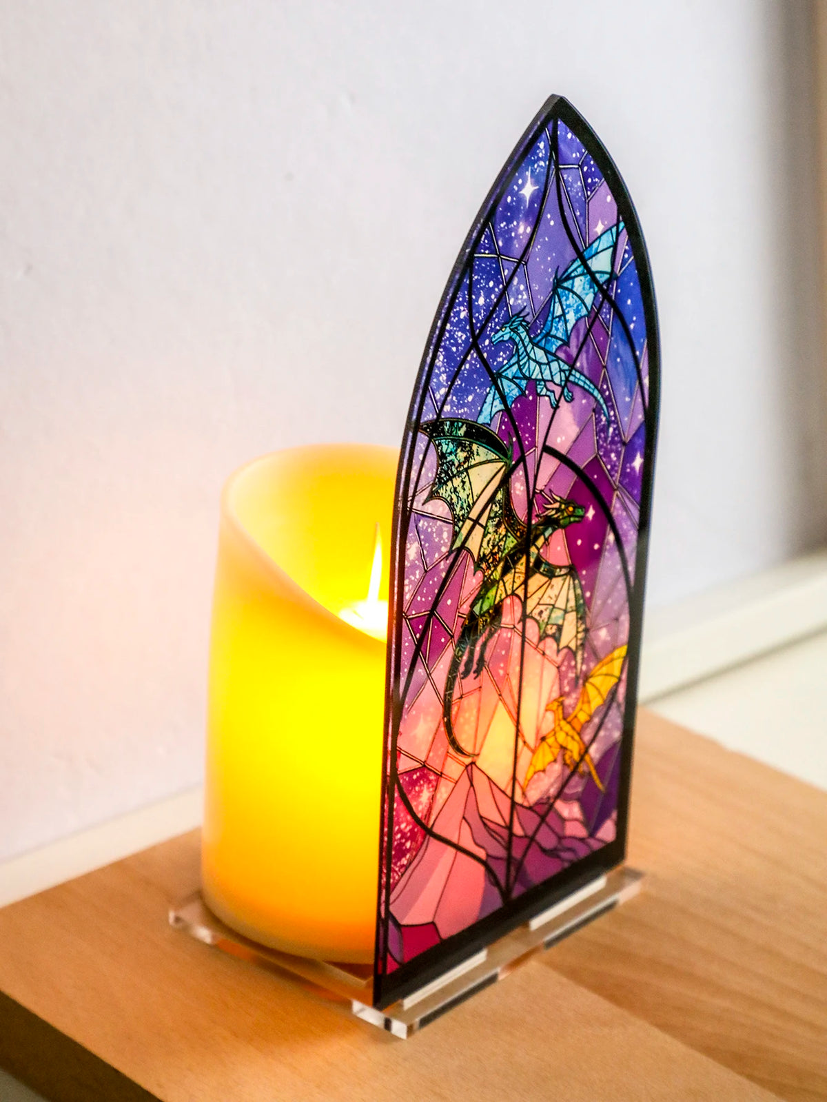 Porta-velas de arco gótico con diseño de vidrieras de dragón en tonos morado y rosa.