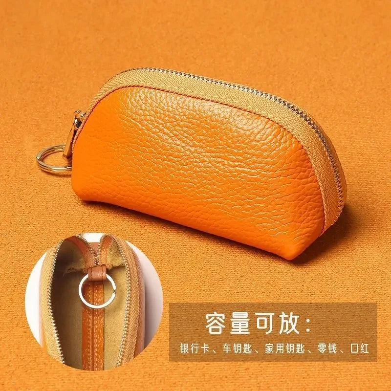 Orange leather key organizer wallet with zipper closure shown against an orange background.