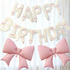 A banner decoration set featuring white and pink balloon letters spelling out HAPPY BIRTHDAY