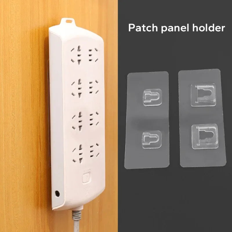 A white patch panel holder device is shown mounted on a wooden surface next to two clear adhesive wall hooks.