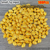 A pile of small 1 gram gold ingots or decorative ornaments in a golden yellow color.