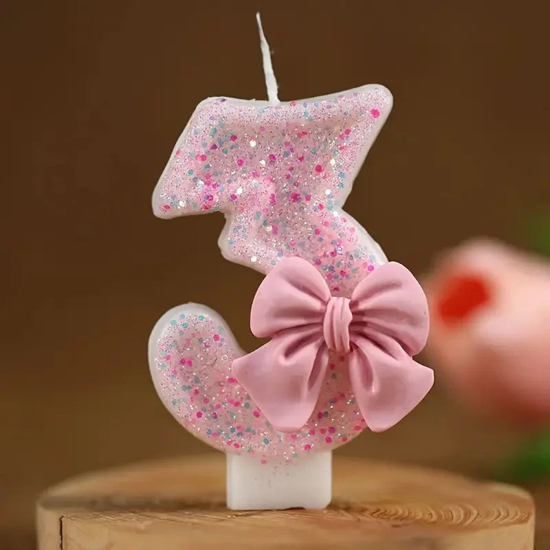 Glitter number birthday candle shaped like the number 3 with a pink bow