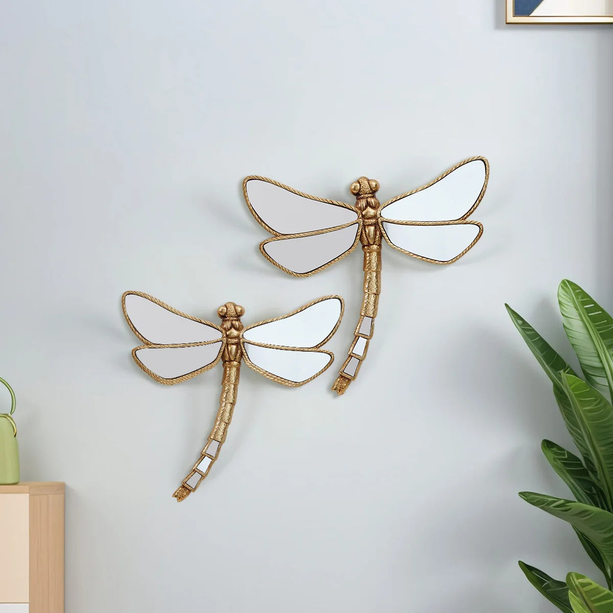 Golden dragonfly mirror wall decor featuring a metallic gold frame and translucent wings.