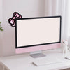 Un moniteur d'ordinateur blanc avec une bordure rose repose sur un bureau blanc à côté d'une petite figurine de chat blanc.