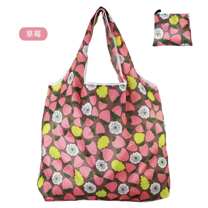 Wiederverwendbare Tasche mit Muster aus rosa Erdbeeren und grünen Blättern.