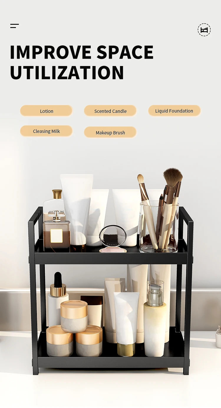 A black two-tier desktop storage rack holding various beauty and skincare products like lotion, candles, and foundations.