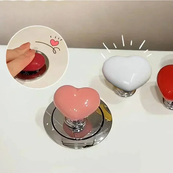 A collection of heart-shaped toilet presser buttons in pink, white, and red are displayed on a white surface.