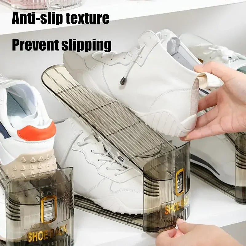 A clear plastic shoe organizer rack holding white sneakers and other shoes.