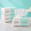 A display of packaged cotton face towels for makeup and cleansing products on a white surface.