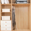 A wooden cabinet with shelves storing white storage boxes and hanging vacuum storage bags.