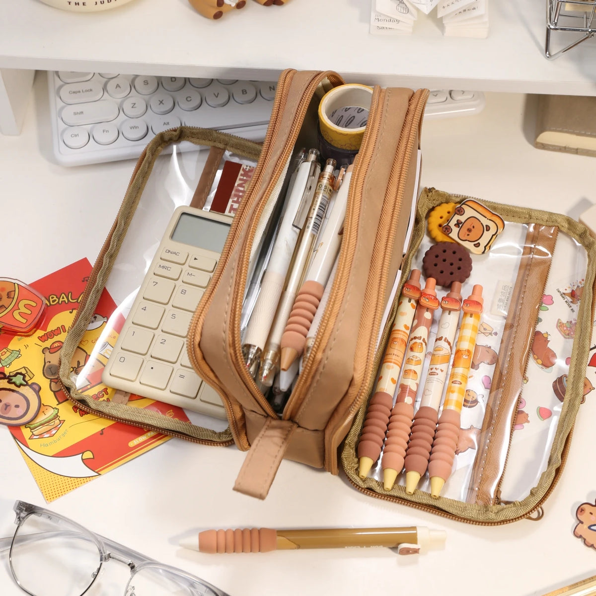 A tan pencil pouch filled with various pens and pencils rests on a white desk next to a calculator.