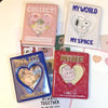 Colección de tres álbumes de fotos rosas y rojos con tapas en forma de corazón y textos como 'Collect My World' y 'Min'