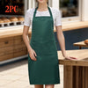 A woman wearing a dark green chef apron with a pocket, standing in a kitchen setting.