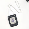 A dark gray police officer badge with a silver emblem and a chain necklace is displayed on a white background.