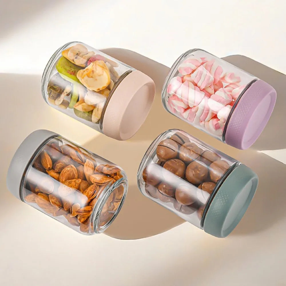 Four glass meal prep jars with airtight lids filled with various dried fruits and nuts