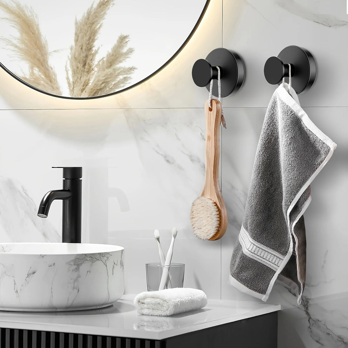A bathroom vanity featuring a black faucet, white marble sink, and a towel rack with suction cup hooks.