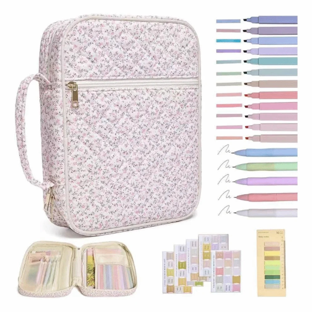 A floral quilted bible cover bag with a zipper and handle, shown alongside various colored pens and pencils.