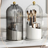 Klares Glas-Kosmetikorganizer mit rotierbarem Deckel, der verschiedene Make-up-Pinsel und Werkzeuge aufbewahrt.
