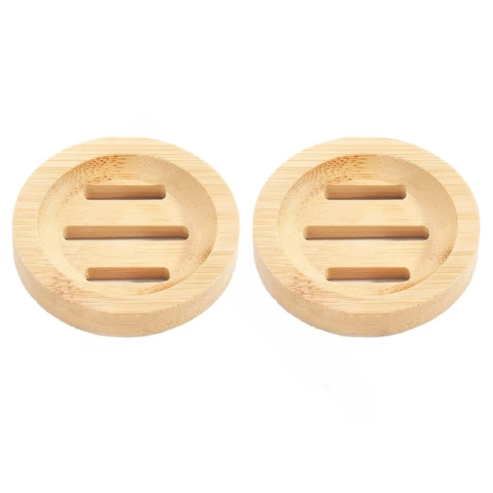 A pair of natural wooden soap dishes with slotted drainage holes.
