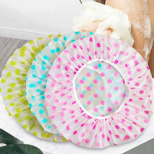 Ein Set aus drei farbigen, wasserdichten Einweg-Duschhauben mit rosa, grünem und blauem Polka Dots.