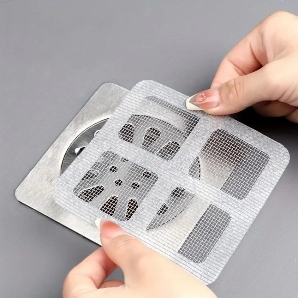 Eine Hand hält einen Einweg-Abflussfilteraufkleber, ein perforiertes Plastikblatt mit verschiedenen Formen für den Haushalt