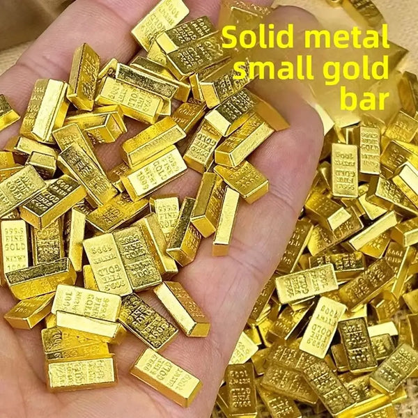 Une main tient une pile de petites barres d'or solide, qui sont des ornements décoratifs.