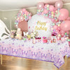 Table decorated with watercolor butterfly tablecloth and pink and purple balloons for a birthday party.
