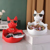 A white French bulldog sculpture is shown with an open mouth holding a coin bank and snack holder on a white pedestal.
