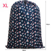 Large capacity drawstring storage bag for laundry and bedding in navy blue with pink floral pattern