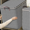 A hand is opening a patterned storage box covered in a black and white houndstooth fabric.
