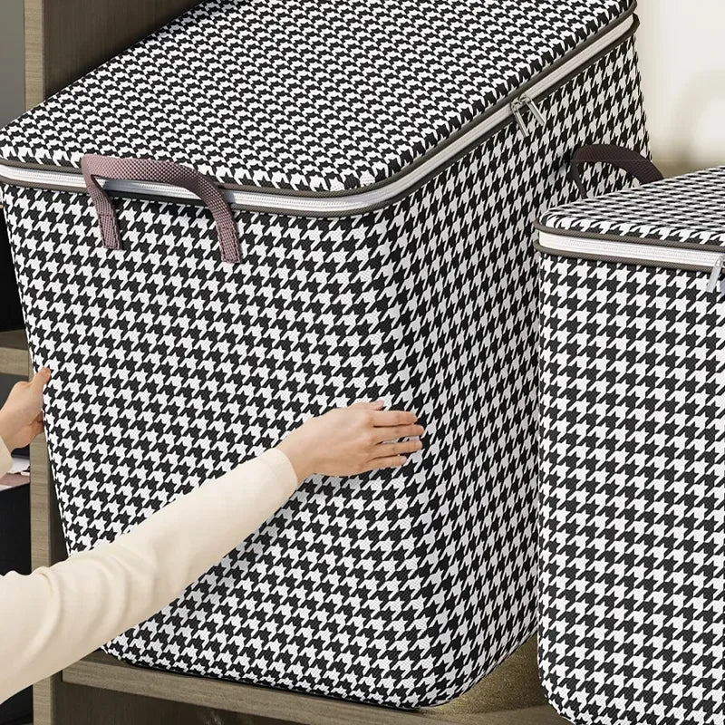 A hand is opening a patterned storage box covered in a black and white houndstooth fabric.