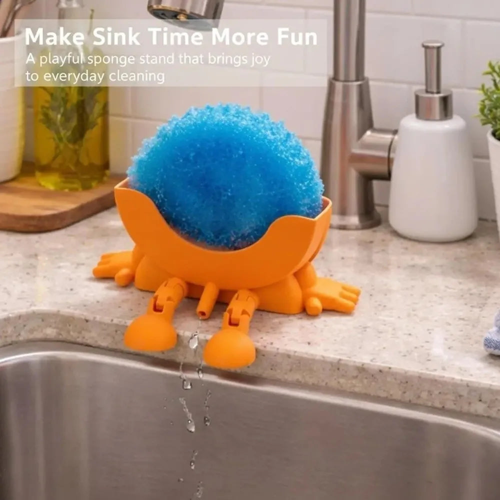 An orange sponge holder with a bright blue sponge sits in a kitchen sink.