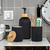 A set of black and wood bathroom countertop organizers including a soap dispenser, brush holder, and toothbrush stand.