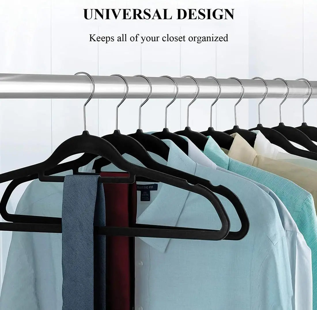 A set of black velvet slim hangers hanging on a metal rod, used for organizing a closet.