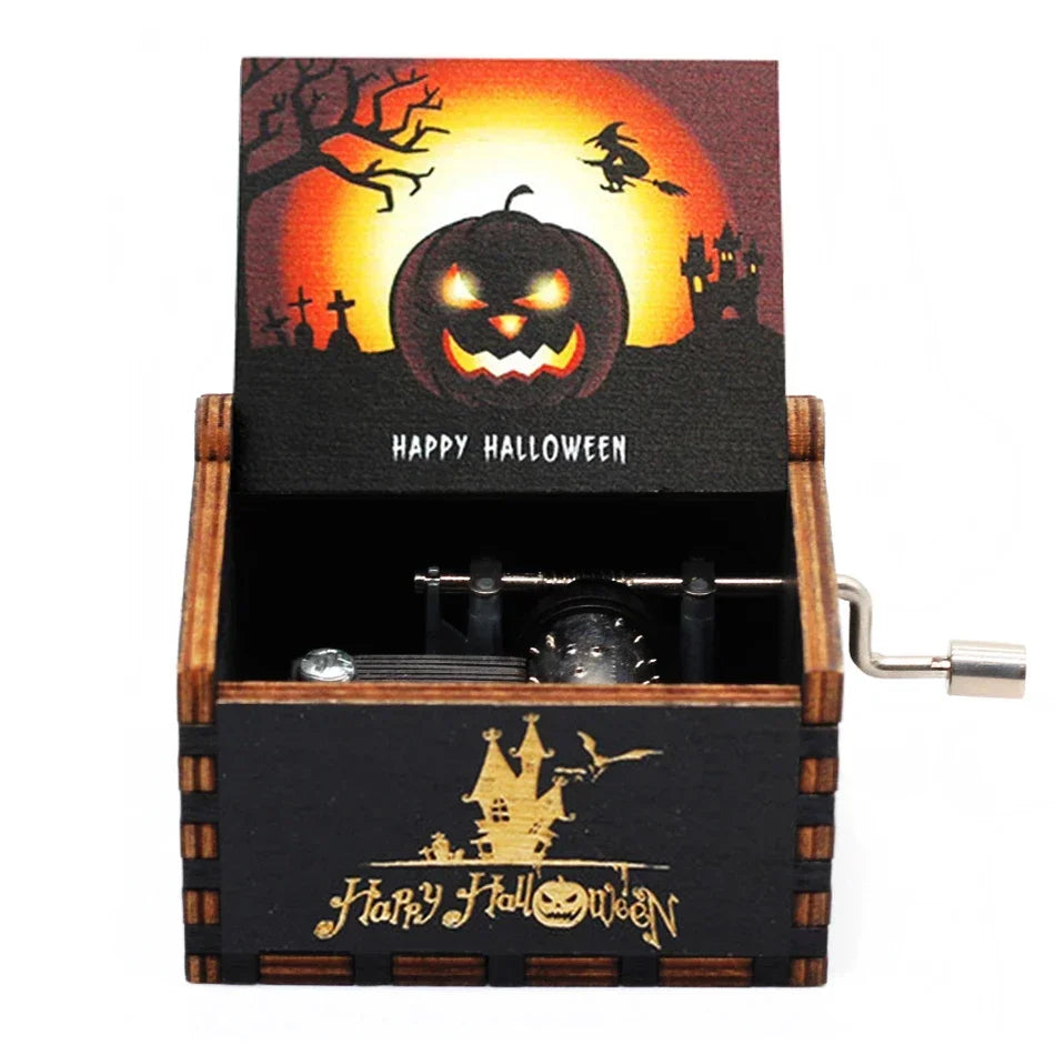 A wooden box containing a Halloween themed card featuring a carved pumpkin and bats, with an antique hand crank visible.