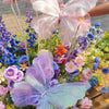 Pink and purple 3D simulated butterfly decorations arranged in a floral display.