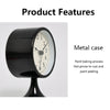 A black metal round table alarm clock with a white face and a dark finish.