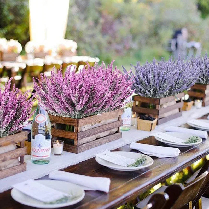 A display of artificial purple lavender flowers in wooden boxes on a rustic table.