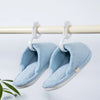 Light blue fuzzy hanging shoe organizer hooks suspended from a wooden bar
