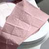 Pinker Einweg-Toilettendeckelsatz mit Wassertropfen auf dem Stoff