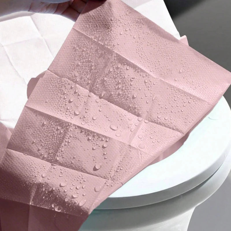 Pinker Einweg-Toilettendeckelsatz mit Wassertropfen auf dem Stoff