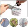 Hands are using scissors to cut and apply heavy duty waterproof window screen repair tape on a window.