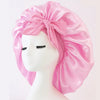 Rosa Satin-Seiden-Haube mit großer Schleife auf weißem Mannequin-Kopf.