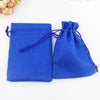 Zwei leuchtend blaue handgefertigte Jute- und Leinen-Geschenktaschen auf einer weißen Oberfläche.