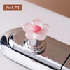 Pink flower shaped toilet flush button with a pink and red center