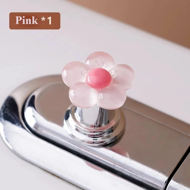 Pink flower shaped toilet flush button with a pink and red center