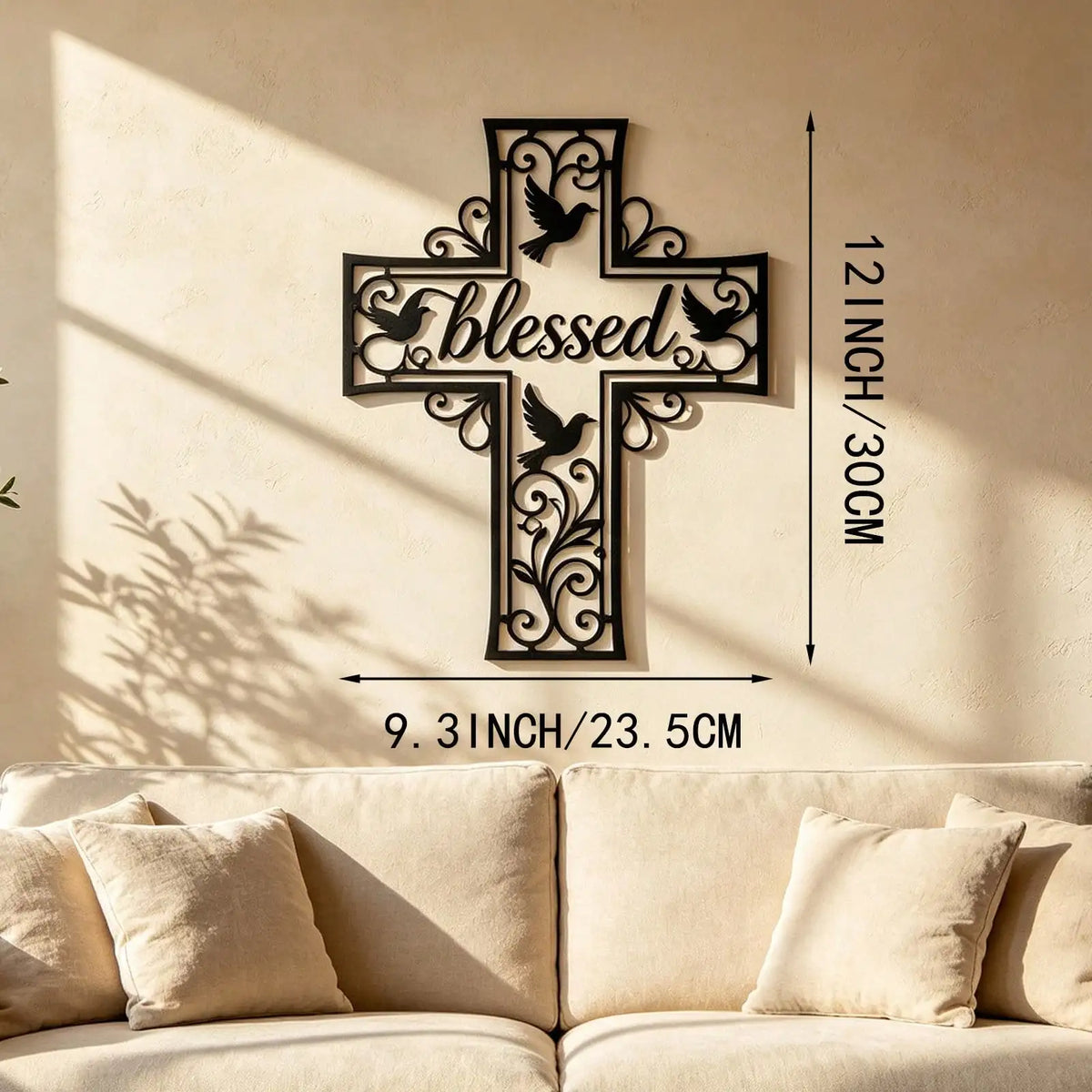 A black metal cross wall art decoration with a dove design mounted on a beige wall.